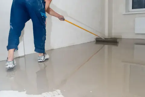 Robot do wylewki maszynowej wygładza świeżą wylewkę podłogową.