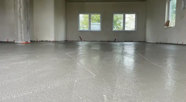 Świeżo wylana wylewka betonowa w nowym budynku. Zastanawiasz się, ile kosztuje wylewka betonowa? To kluczowy etap budowy.